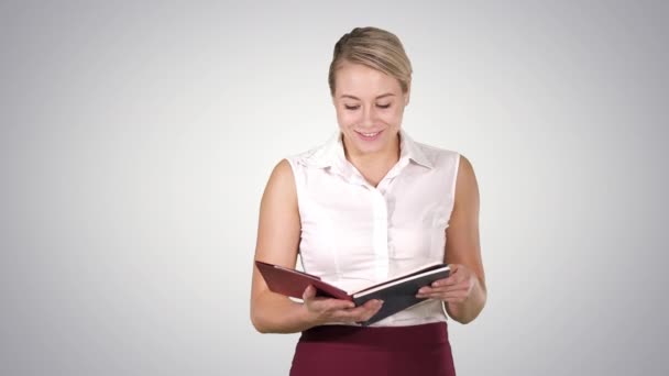 Frau hält Buch oder Notizbuch hoch und liest laut vor, Alphakanal — Stockvideo