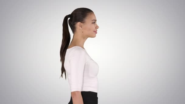 Jonge zakenvrouw loopt op gradiënt achtergrond. — Stockvideo