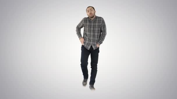 Jonge man lopen met handen in zijn zakken en fluitjes op verloop achtergrond. — Stockvideo