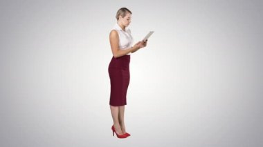 Gradyan arkaplan üzerinde dijital tablet kullanan güzel modern kadın.