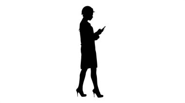 Siluet Mühendisi yürürken cep telefonu mesajı kullanıyor.