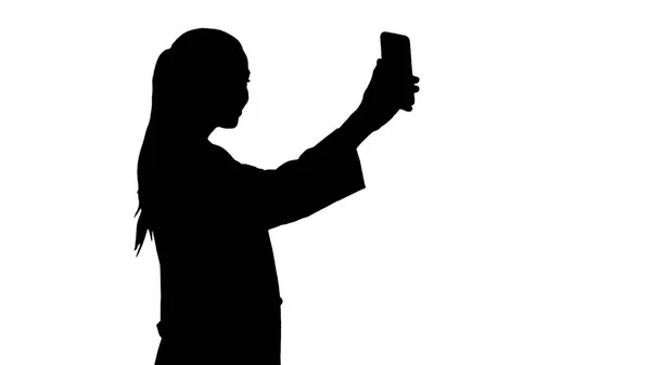 Silhouette Elegante medico europeo bruna scattare selfie al telefono mentre si cammina . — Foto Stock