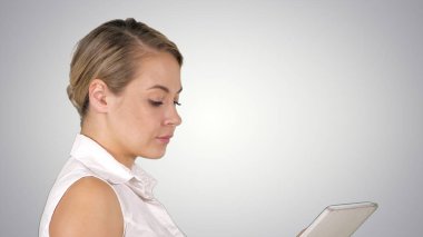 Yürüyüş ve medya içeriği bir tablet degrade arka plan üzerinde bir satır izlerken tek kız.