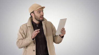 Genç işadamı degrade arka plan üzerinde video arama yapma dijital tablet kullanma.