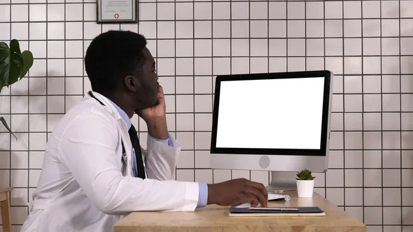 Młody lekarz Afryki, patrząc na monitorze swojego komputera. Biały wyświetlacz. — Zdjęcie stockowe