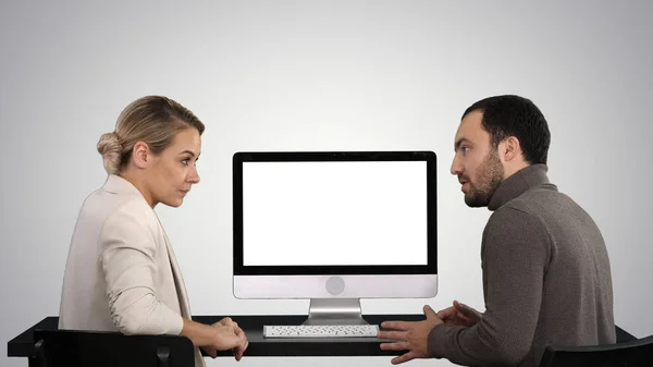 Personas de negocios que se reúnen alrededor del monitor de la computadora hablando de lo que está en la pantalla en el fondo del gradiente . —  Fotos de Stock