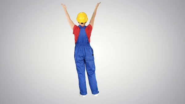 Junge Bauarbeiterin macht ausdrucksstarke Gesten im Gespräch mit Krabbeltieren auf Steigungshintergrund. — Stockfoto