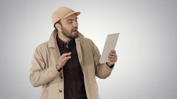 Jeune homme d'affaires utilisant une tablette numérique faire appel vidéo sur fond de dégradé . — Photo