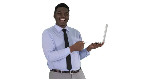 Parlando con la macchina fotografica giovane uomo africano con il computer portatile in mano su sfondo bianco. — Foto Stock