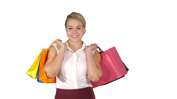 Jovem mulher andando e segurar sacos de compras ao fazer algumas compras no fundo branco. — Fotografia de Stock