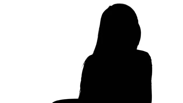 Silhouette Portrait de jeune femme souriante faisant un appel assis. — Photo