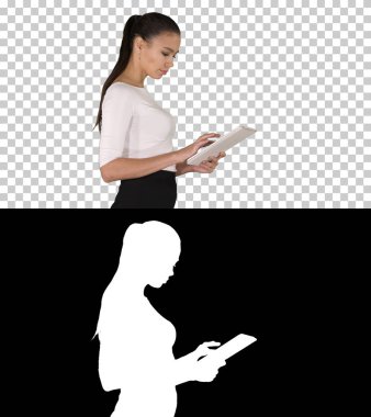 Yürürken dijital tablet kullanan çekici iş kadını, Alpha Channel