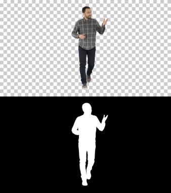 Gömlekli ve kot pantolonlu genç adam kameraya doğru yürüyor ve kenarları işaret ediyor, Alpha Channel.