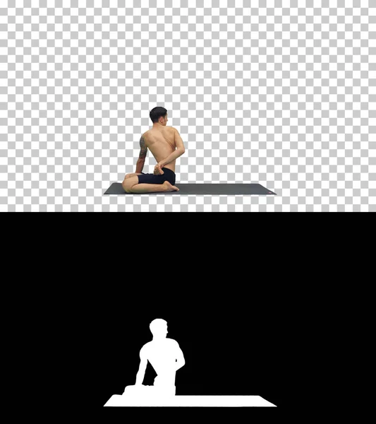 ヨガの練習をしている若い強い男がパドマサナの足、アルファチャンネルを伸ばし — ストック写真