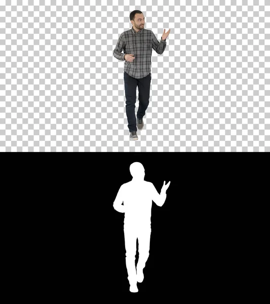 Jonge zelfverzekerde man in shirt en jeans loopt naar de camera en wijst naar de zijkanten, Alpha Channel — Stockfoto