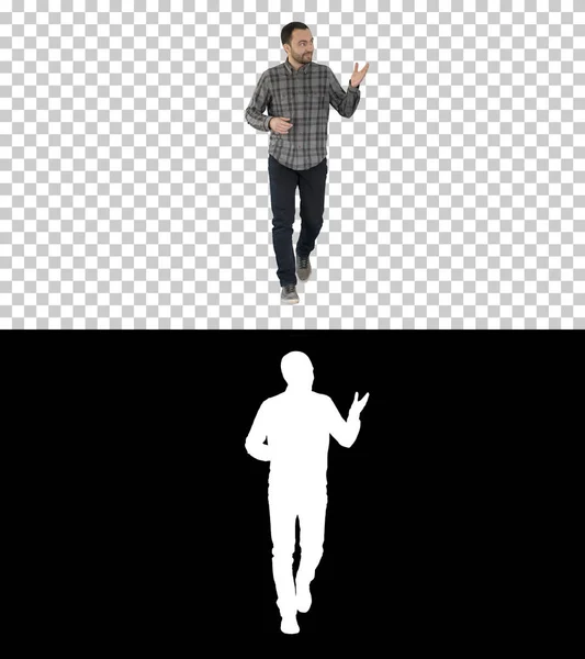 Gömlekli ve kot pantolonlu genç adam kameraya doğru yürüyor ve kenarları işaret ediyor, Alpha Channel. — Stok fotoğraf