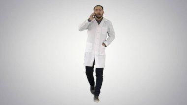 Erkek doktor telefonda gradyan arka planda yürüyor ve konuşuyor..