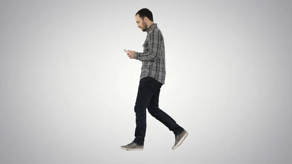 Homem sério confiante andando e trabalhando em tablet em fundo gradiente . — Fotografia de Stock