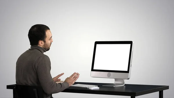 在梯度背景下在电脑上进行视频通话的年轻商人. — 图库照片