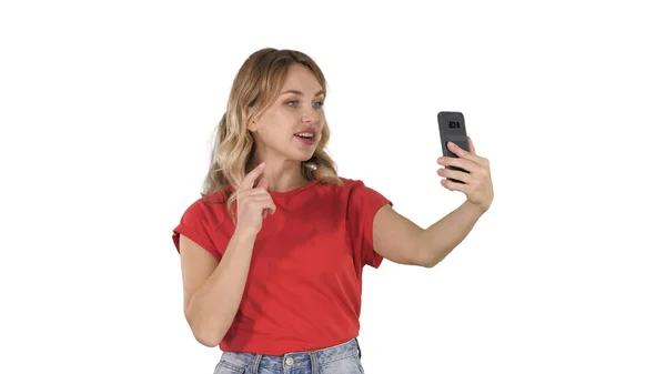 Fröhliche Bloggerin, die vor der Kamera eines modernen Telefons ein Video aufnimmt, während sie auf weißem Hintergrund läuft. — Stockfoto
