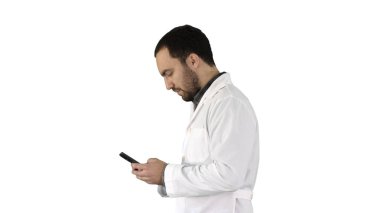 Yürüyen doktor ya da hemşire beyaz arka planda cep telefonuyla mesaj atıyor..