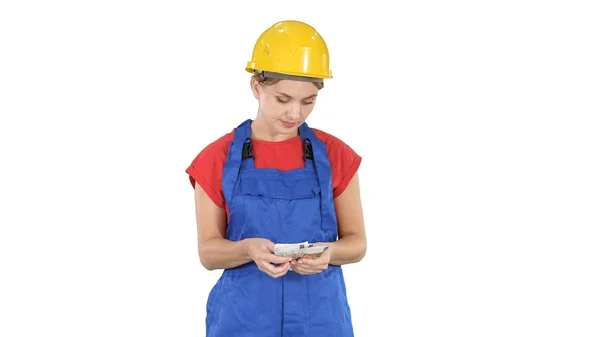 Young cheerful female worker holding salary banknotes in euro on white background. Stock Picture