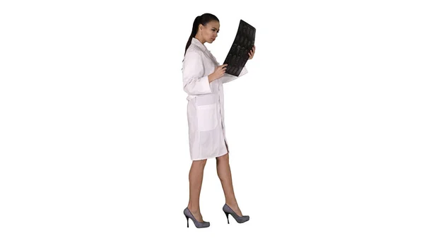 Intellektuell kvinna vårdpersonal med vit labcoat, tittar på röntgen röntgen bild, ct scan, MRI på vit bakgrund. — Stockfoto