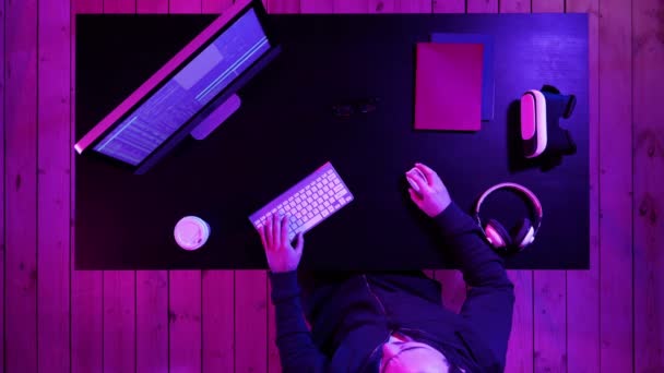 Jeune homme programmeur ou hacker travaillant sur ordinateur la nuit. — Video