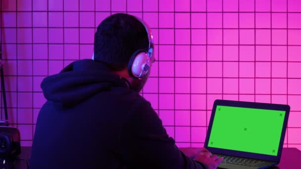 Man in hoofdtelefoon afspelen van video game thuis. Groen scherm Mock-up Display. — Stockvideo