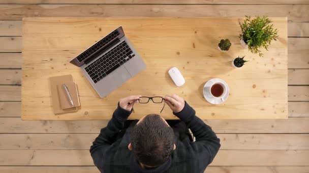 Επιχειρηματίας φορώντας γυαλιά και κάθεται στο laptop του. Σκούπισμα γυαλιά. — Αρχείο Βίντεο