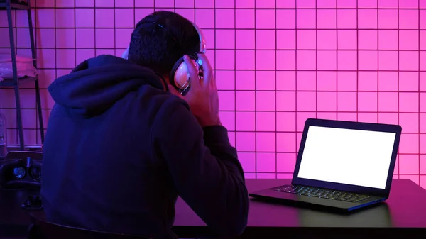 Gamer indossa auricolare guardando flusso di una partita. Display bianco. — Foto Stock