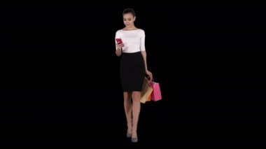 Akıllı telefonlu mutlu genç bir kadın alışveriş çantalarının fotoğrafını çekiyor, Alpha Channel.
