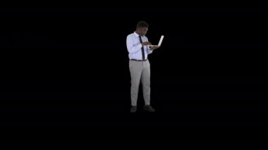 Alpha Channel 'da dizüstü bilgisayarla çalışan Afro-Amerikalı iş adamı.