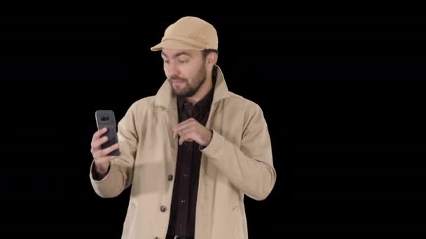Ung man ringer ett videosamtal från sin mobiltelefon när han går, Alpha Channel — Stockvideo