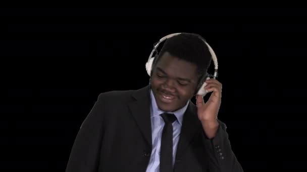 Чёрный бизнесмен танцует под музыку в наушниках, Альфа-канал — стоковое видео