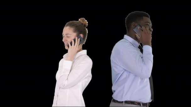 Young African American man and woman standing back to back making phone calls, Alpha Channel — Stock Video