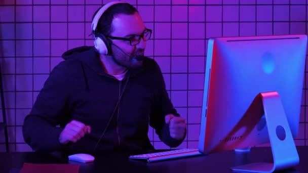 Glücklicher junger Mann mit Brille, Headset und siegreichem Computerspiel. — Stockvideo