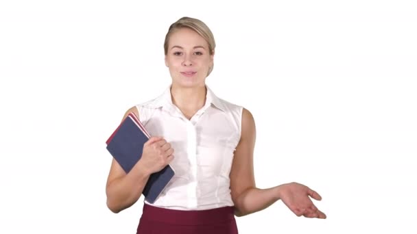 Hermosa maestra con cuadernos explicando algo a la cámara sobre fondo blanco. — Vídeos de Stock