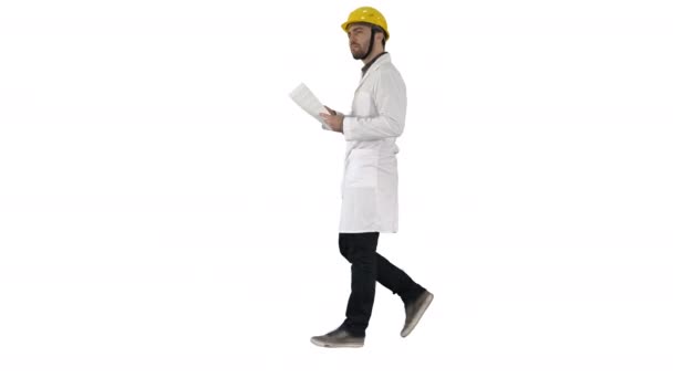 Ingénieur gestionnaire marche avec un casque dur tient le papier et vérifier sur fond blanc. — Video