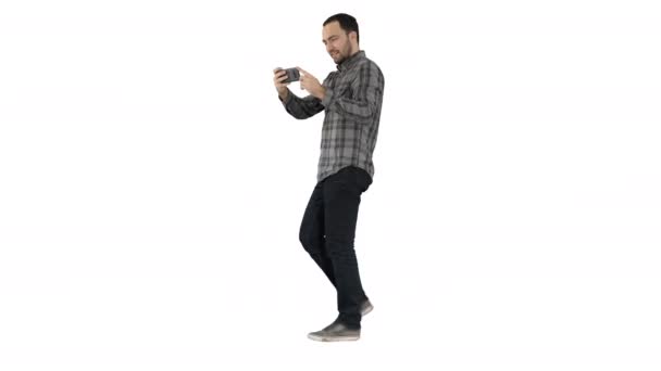 Ung man att ta foto med smartphone medan promenader på vit bakgrund. — Stockvideo
