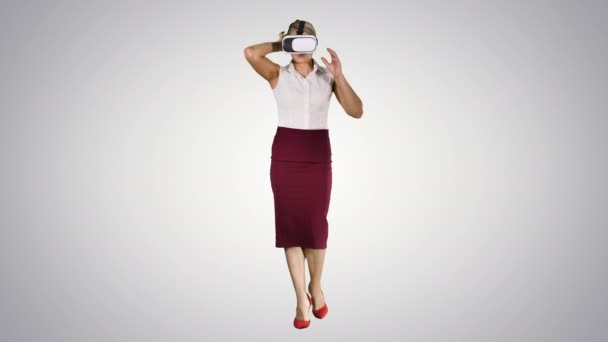 Marcher jeune femme en utilisant des lunettes vr sur fond dégradé. — Video