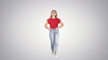 Ona ceplerinde elinizle yürüyüş ve kamera için degrade arka plan üzerinde konuşurken sarışın kadın.