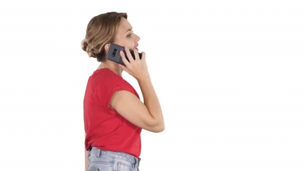 Femme blonde marchant et parlant au téléphone sur fond blanc . — Video