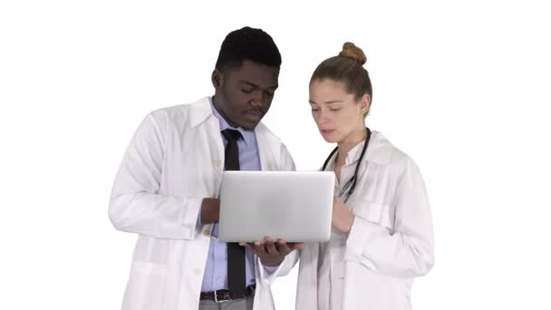 Personal médico trabajando frente a un portátil gris mientras está de pie sobre fondo blanco . — Vídeos de Stock