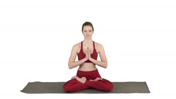 Yoga oturan güzel genç kadın poz Lotus ellerinin beyaz arka plan üzerinde konumunu değiştirme. — Stok video
