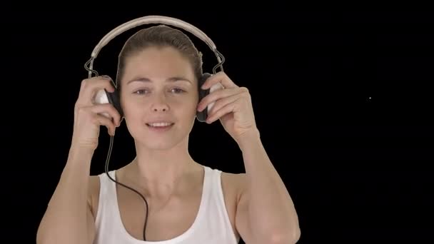 Giovane donna sorridente che ascolta musica con le cuffie, Alpha Channel — Video Stock