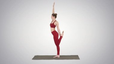Yoga poz dandayamana dhanurasana degrade arka plan üzerinde duran ince kadın.