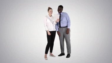 Kafkasyalı genç iş kadını ve Afrikalı meslektaşı gradyan arka planda tabletle video görüşmesi yapıyorlar..