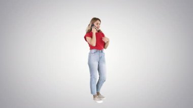Genç bir kadın cep telefonuyla gradyan arka planda konuşuyor.