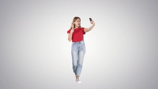 Meraviglioso modello femminile gradiente facendo selfie mentre si cammina su sfondo gradiente . — Video Stock